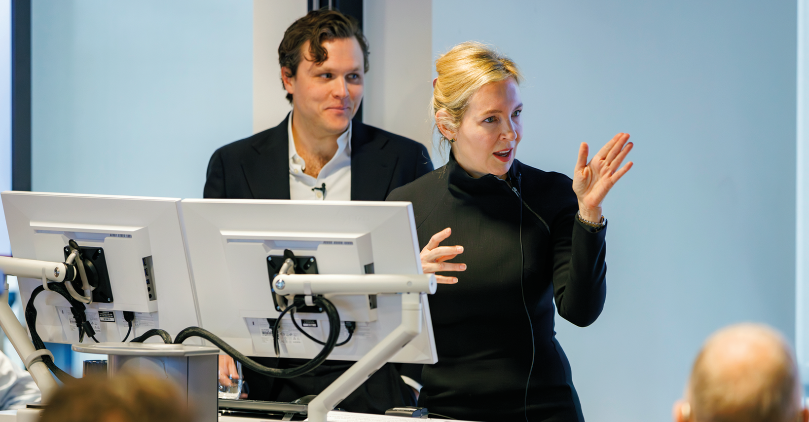 Woman in a black turtleneck speaking at a podium.