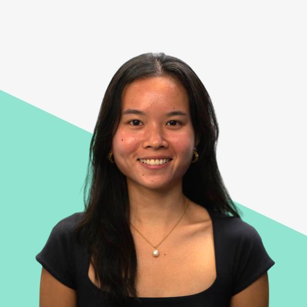 Smiling woman with long black hair, wearing a necklace.