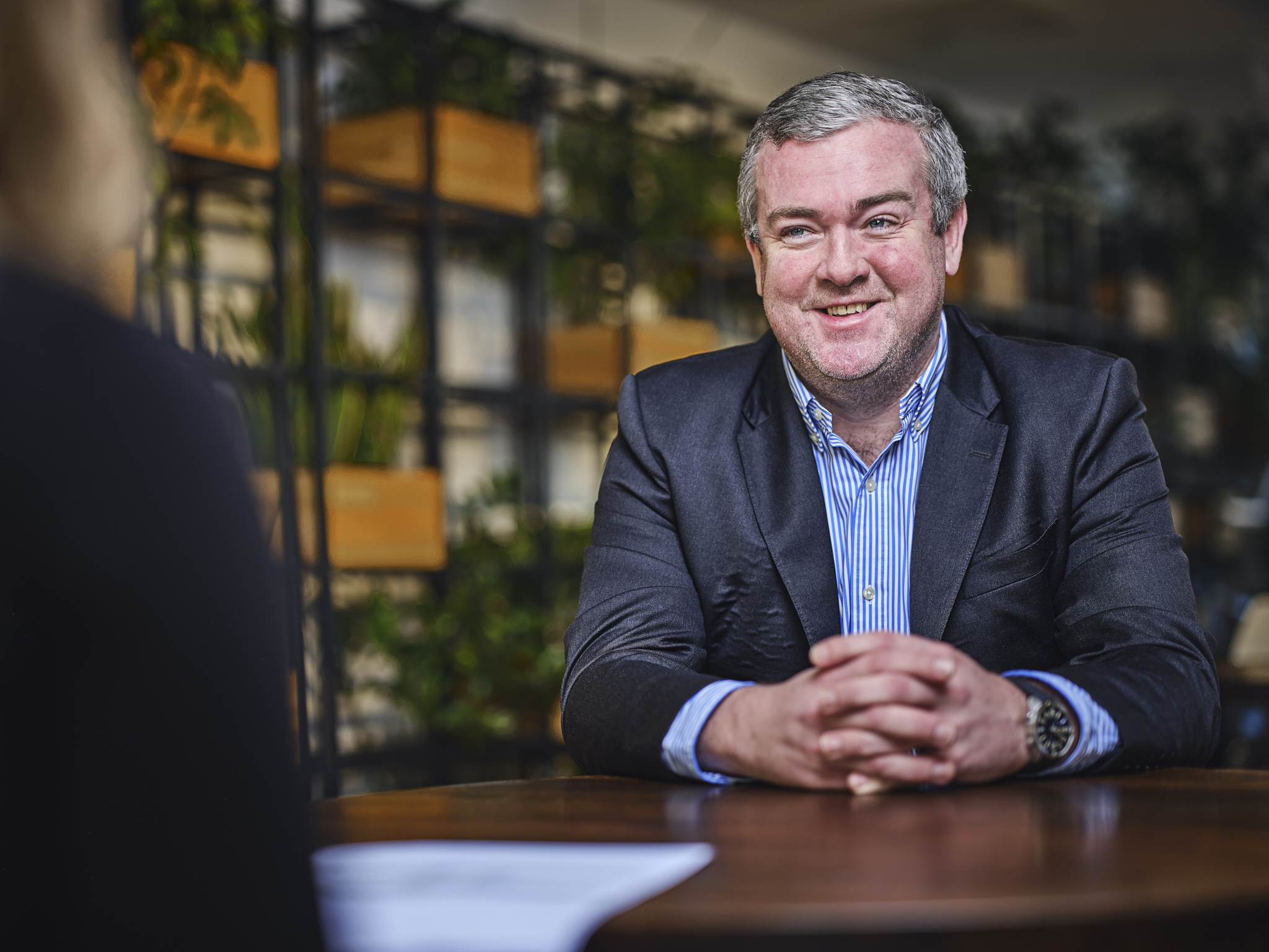 man talking and smiling at table, talking to someone