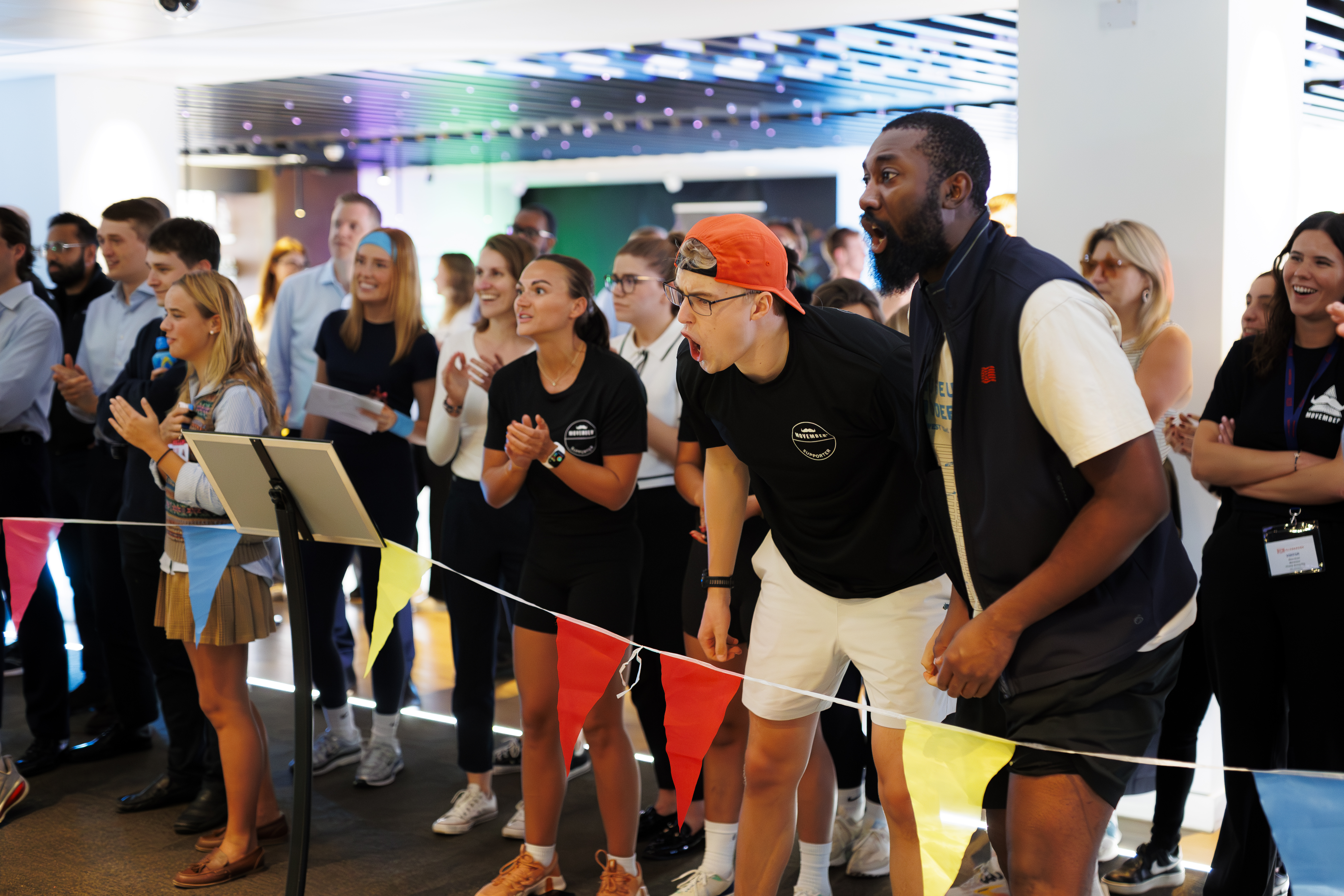 Diverse group gathered in a lively setting with expressions of excitement and engagement.