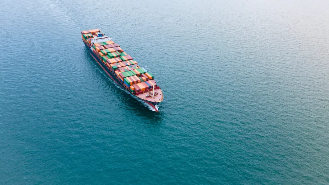 Cargo ship loaded with colourful containers, aerial view