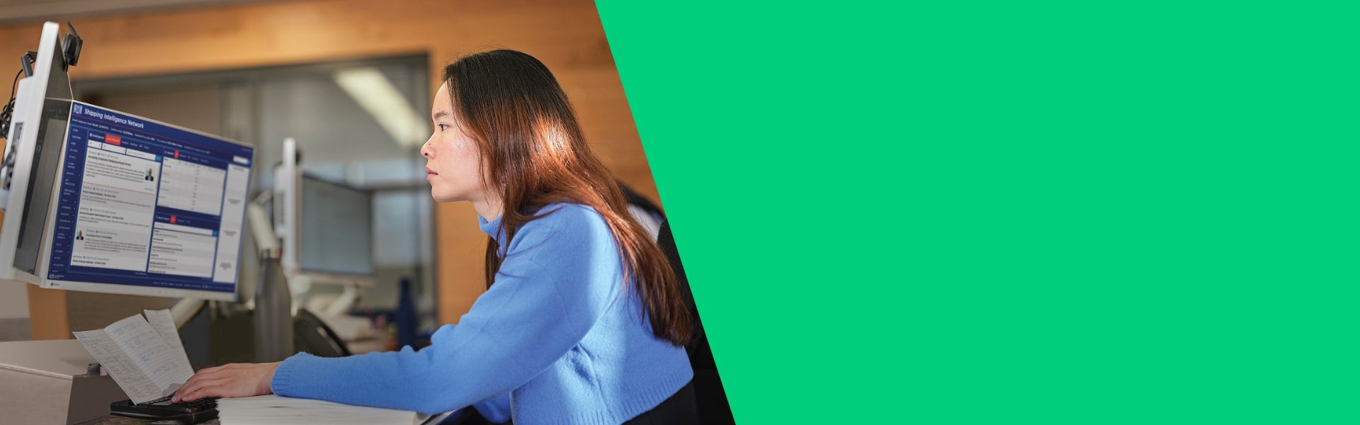 Person working at a computer with a blue sweater.