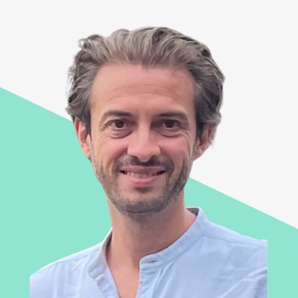 Smiling man with light hair in a blue shirt.