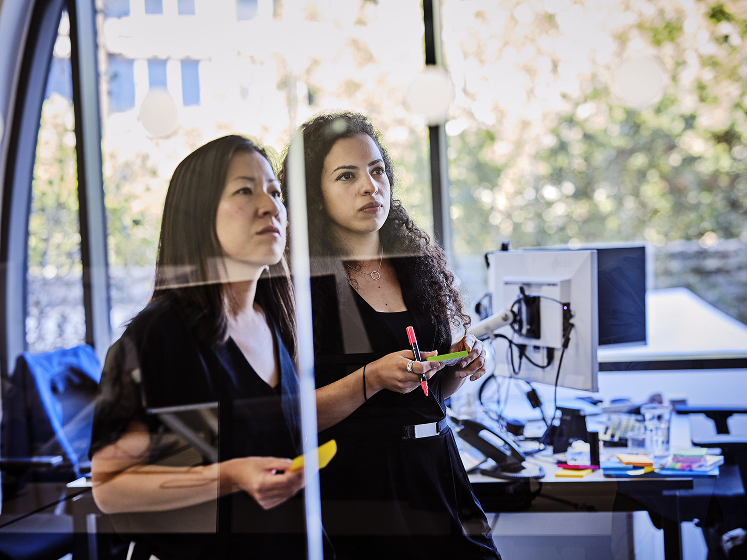 close up of two women looking at notes in a brainstorming meeting