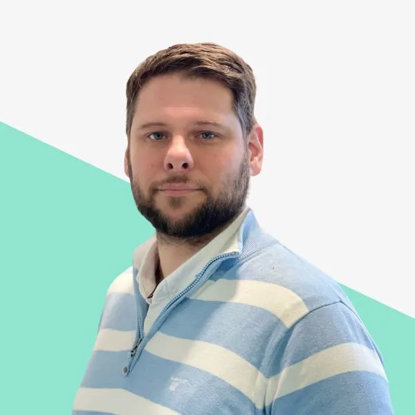 Man with light blue striped sweater, neutral background.