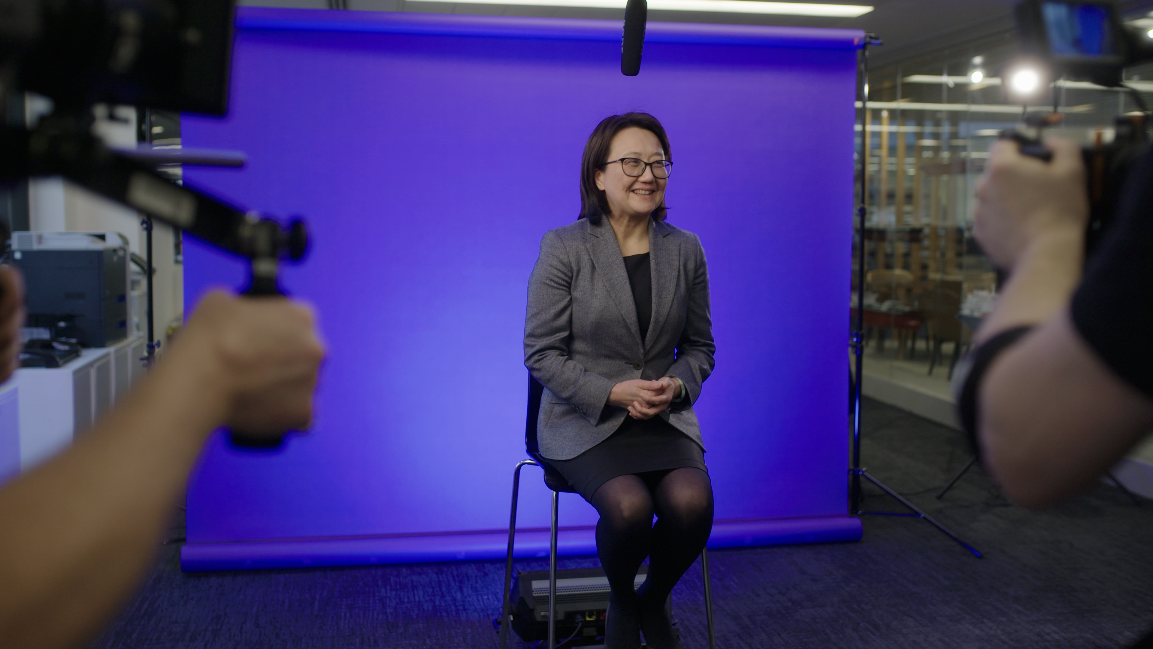 woman sitting in front of film set with purple background
