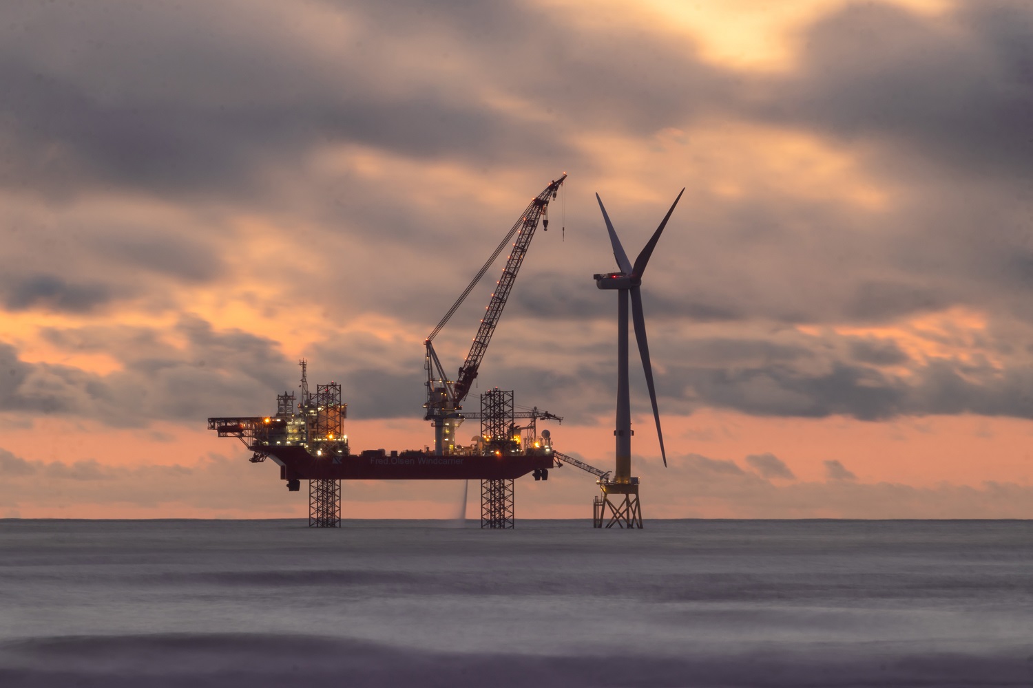 Offshore wind turbine at sunset