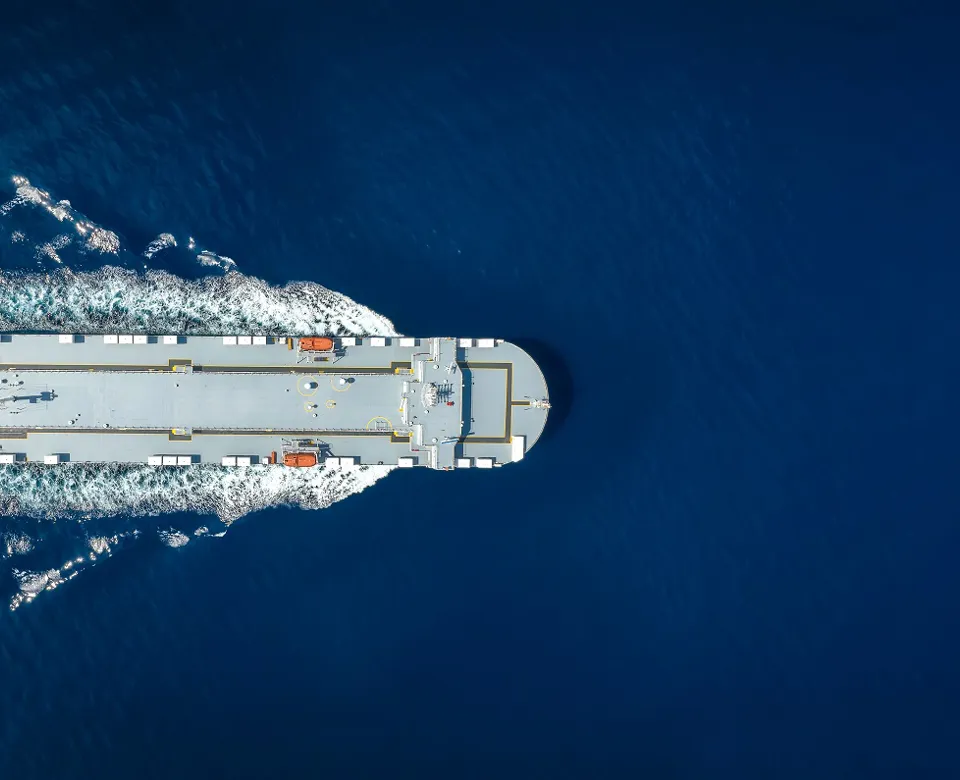 Aerial view of a large ship on deep blue water.