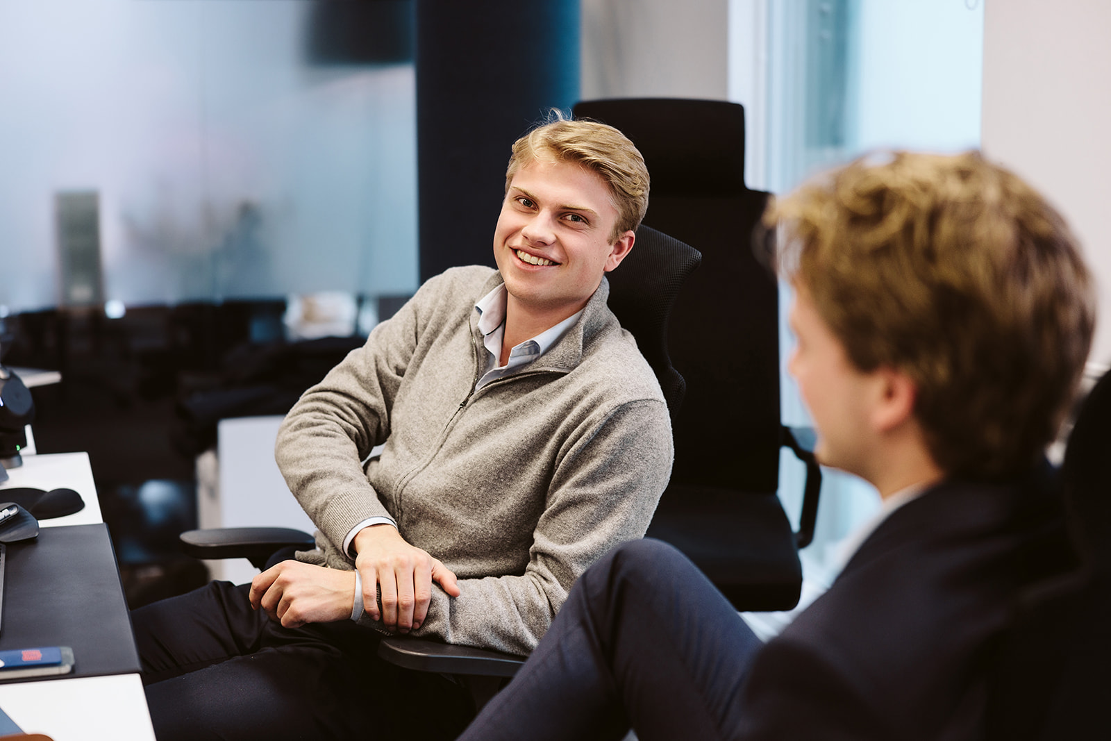 Two young men chatting in an office setting.
