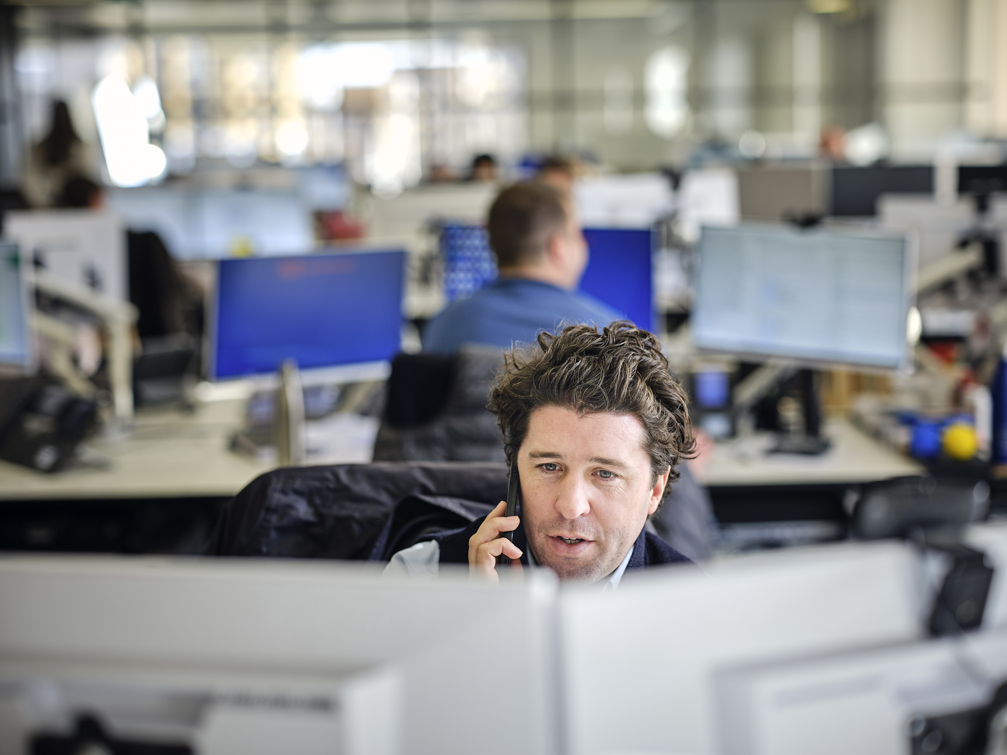 Man talking on the phone in an office environment.