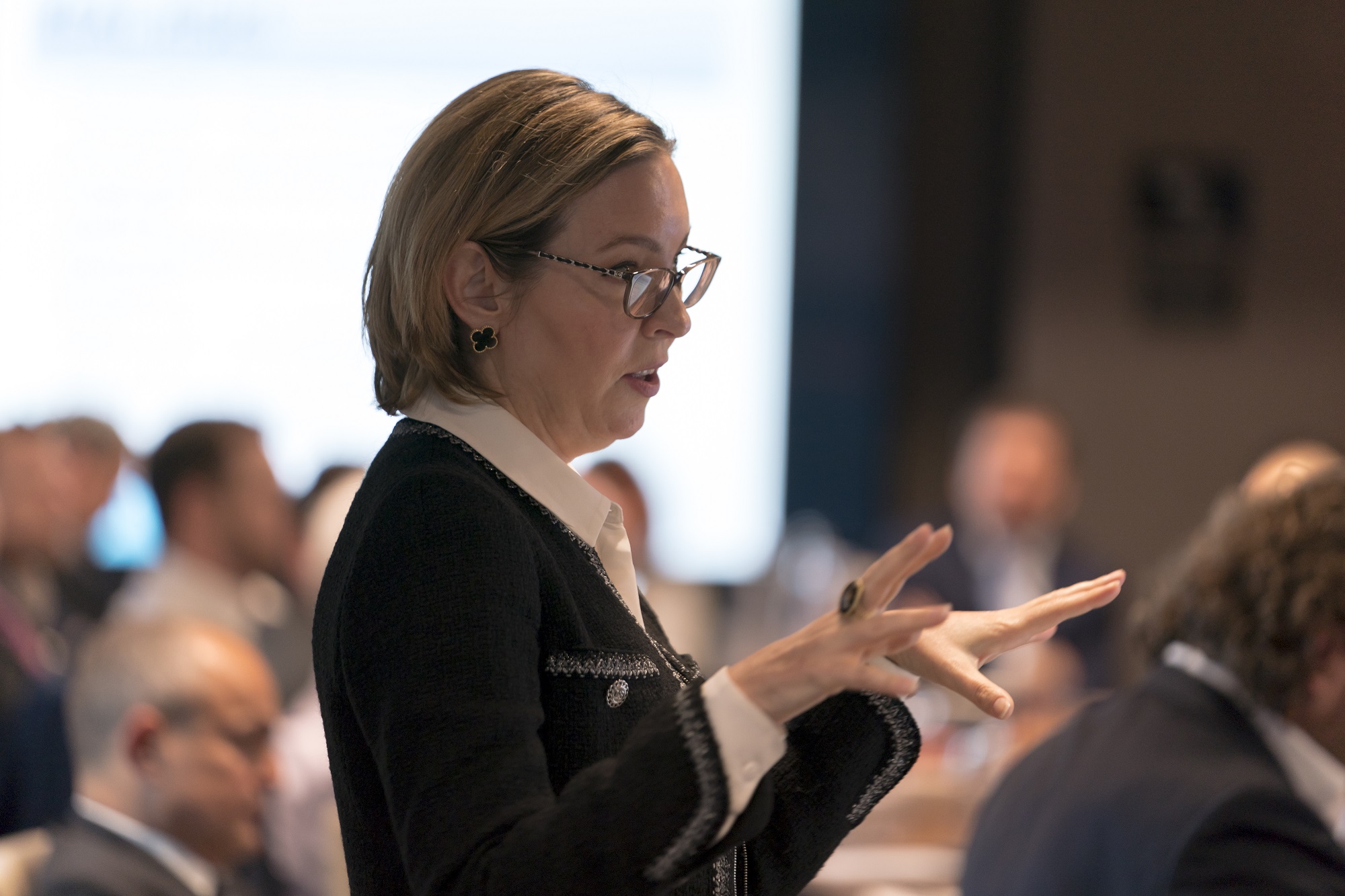 close up of woman standing talking to colleagues