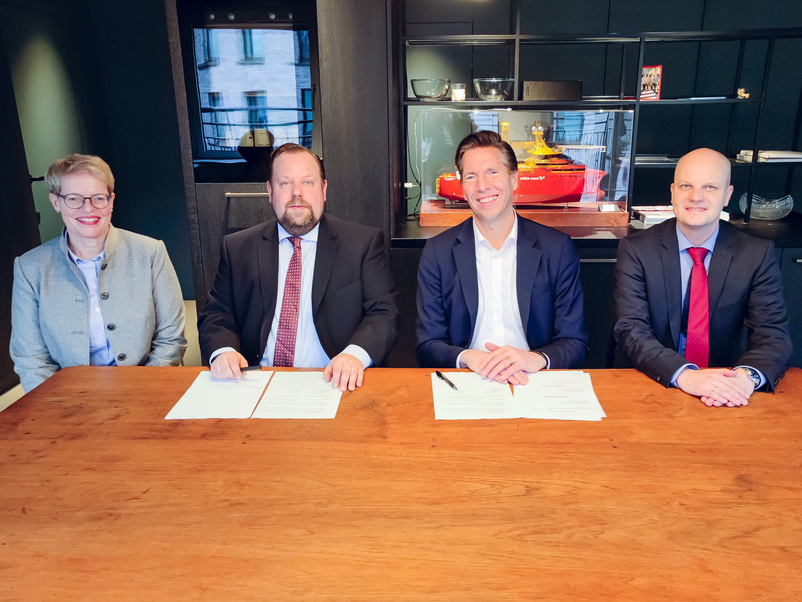Four professionals seated at a table with documents.