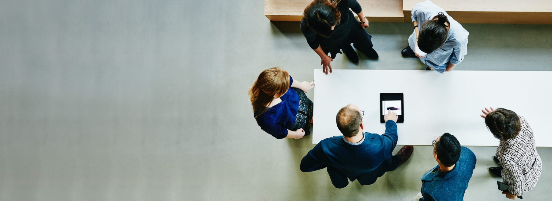 group of people gathered around a table discussing work