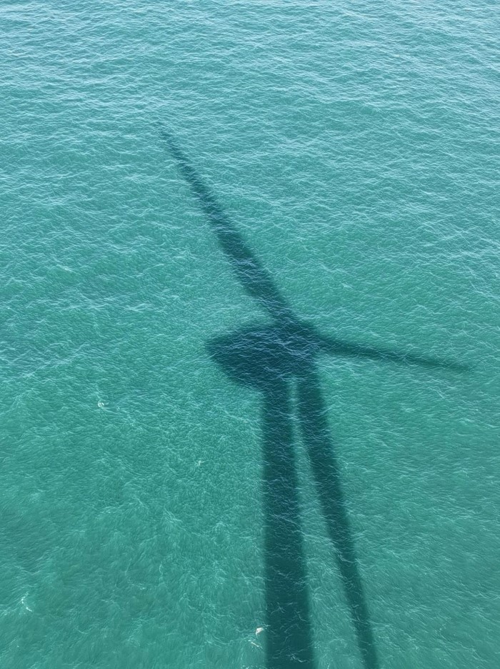shadow of a wind turbine in the water