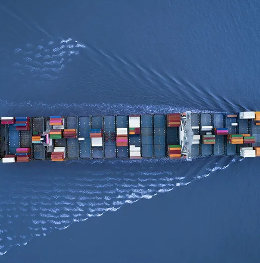 a Large container ship is approaching the port full loaded with containers and cargo, aerial, top down view
