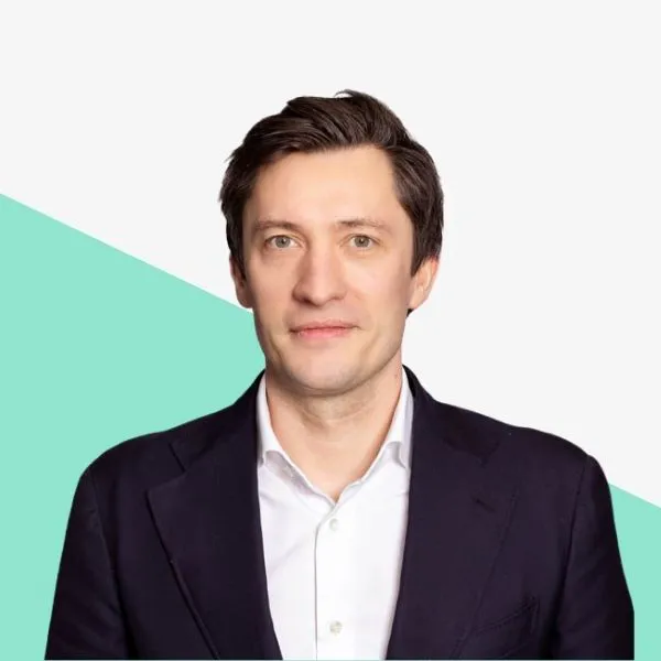 Man in a suit with a light background.