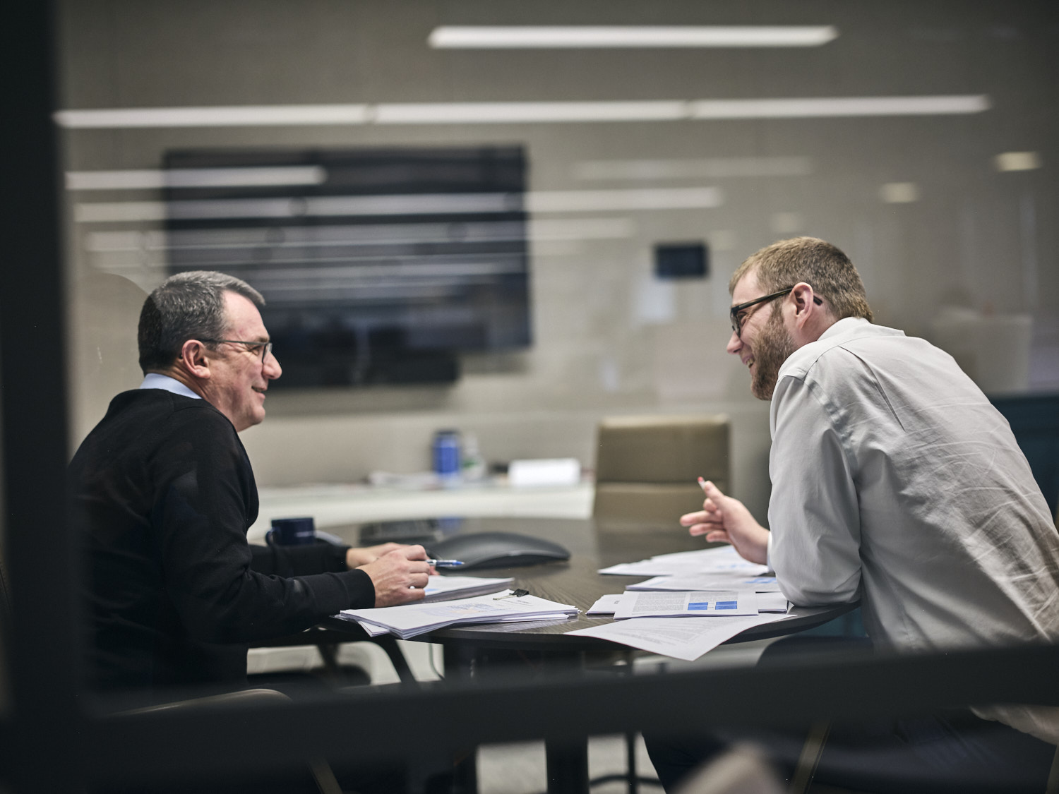 two men discussing work in a meeting room