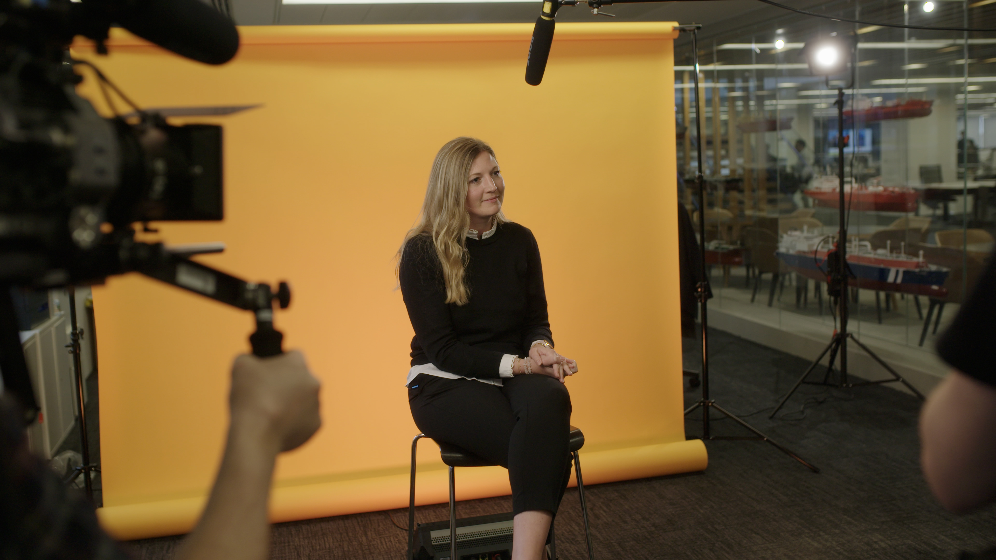 woman sitting in front of film set with yellow background