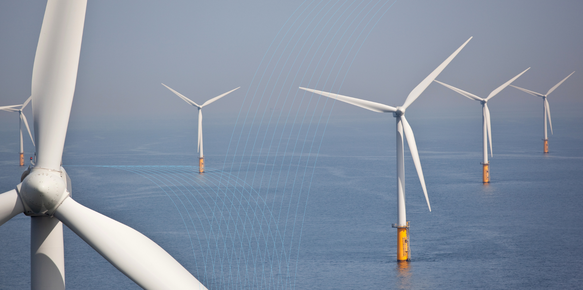 Offshore wind turbines in a clear blue sea.