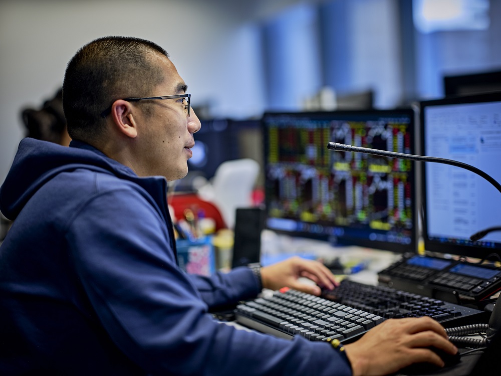 Person using a computer with financial charts displayed.