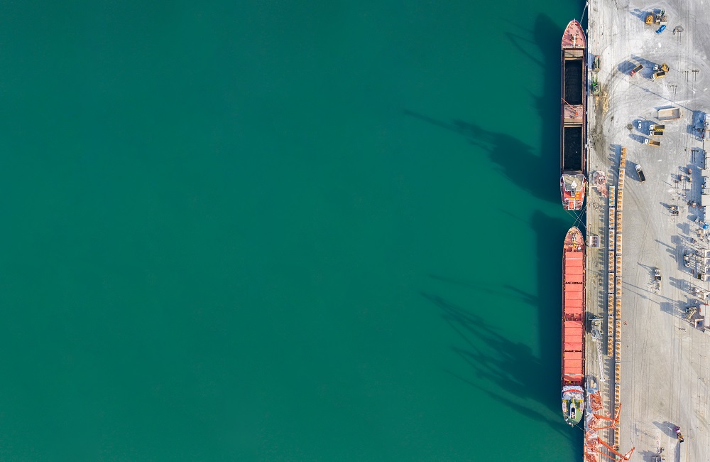 Aerial view of boats by a turquoise harbor.